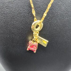 Gold plated travel themed necklace with suitcase and postcard charm